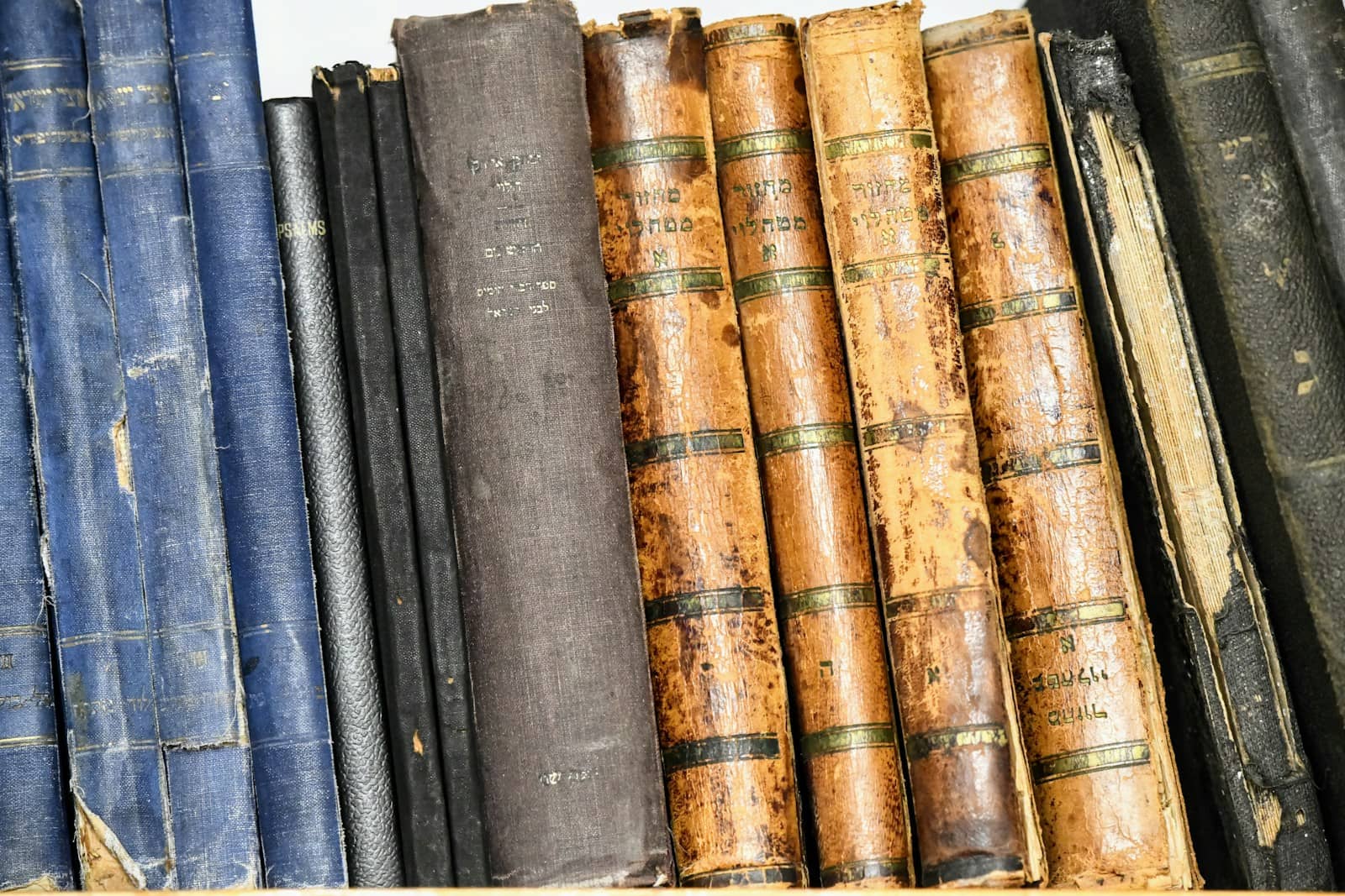 A stack of well-worn career and business books on a wooden desk under warm lighting